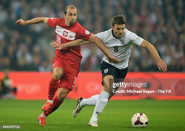 Adrian Mierzejewski of Poland and Michael Carrick of England battle for the ball during the FIFA 2014 World Cup Qualifying Group H match between...