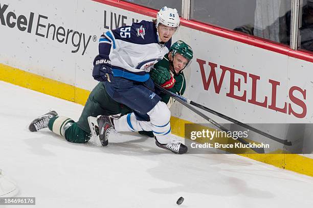 Mark Scheifele of the Winnipeg Jets collides with Mikko Koivu of the Minnesota Wild while skating to the puck during the game on October 10, 2013 at...