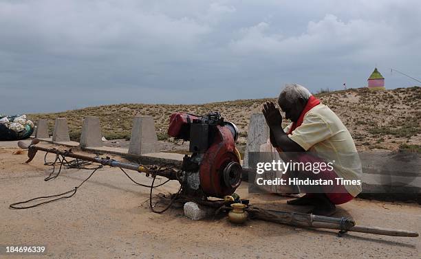 Indian fishermen worshiping engine of his boat on seacoasts at Gopalpur after the cyclone Phailin on October 15, 2013 in Chattapur, India. Cyclone...