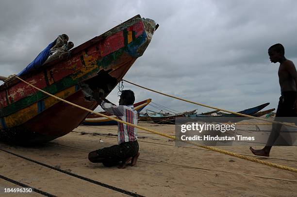 Indian fishermen repairing his boat on seacoasts at Gopalpur after the cyclone Phailin on October 15, 2013 in Chattapur, India. Cyclone Phailin on...