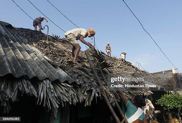 Victims of cyclone Phailin trying to restore their homes at Talatampara village on October 14, 2013 in Srikakulam, India. Cyclone Phailin on Sunday...