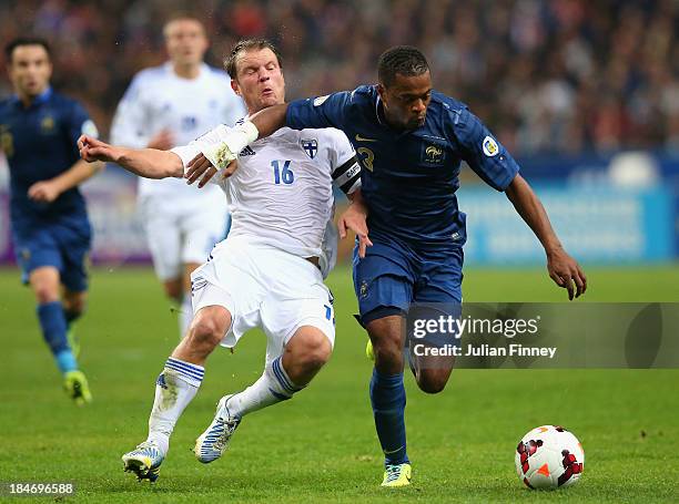 Patrice Evra of France battles with Teemu Tainio of Finland during the FIFA 2014 World Cup Qualifying Group I match between France and Finland at the...