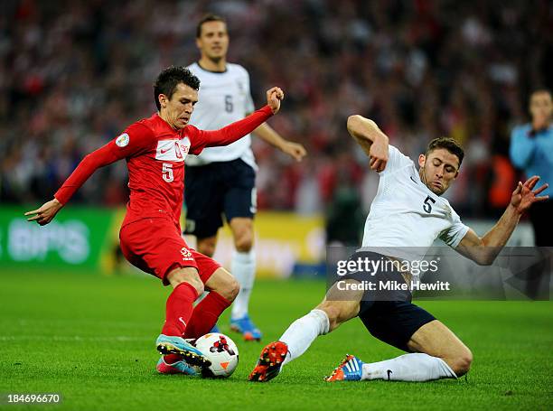 Gary Cahill of England tackles Waldemar Sobota of Poland during the FIFA 2014 World Cup Qualifying Group H match between England and Poland at...