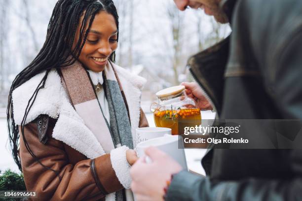 young couple warms up with sea buckthorn tea outdoors - buckthorn stock pictures, royalty-free photos & images