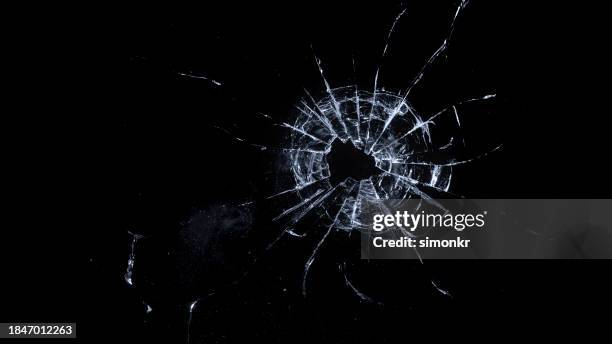 gros plan d’un trou de balle sur du verre - verre brisé photos et images de collection