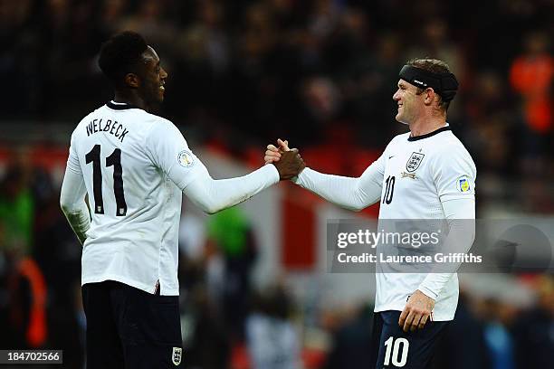 Wayne Rooney of England shakes hands with team mate Danny Welbeck as they qualify for the World Cup in Brazil after the FIFA 2014 World Cup...