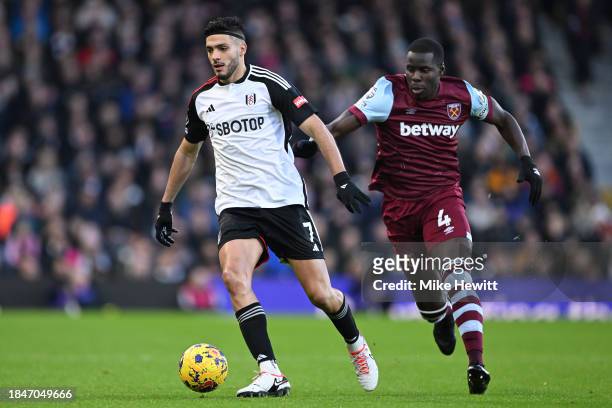 Raul Jimenez of Fulham is challenged by Kurt Zouma of West Ham United during the Premier League match between Fulham FC and West Ham United at Craven...
