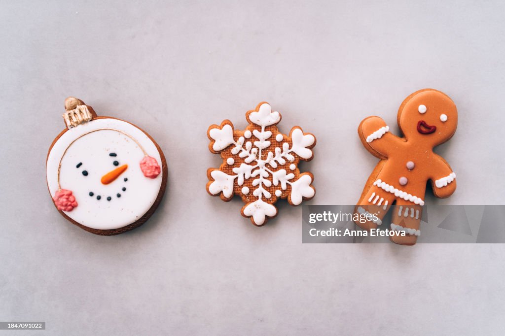 Christmas gingerbread cookies in different shapes: a snowflake, a gingerbread man and a snowman with a cute smiling face. Christmas symbols. Christmas and New Year celebration concept. Frame with copy space.