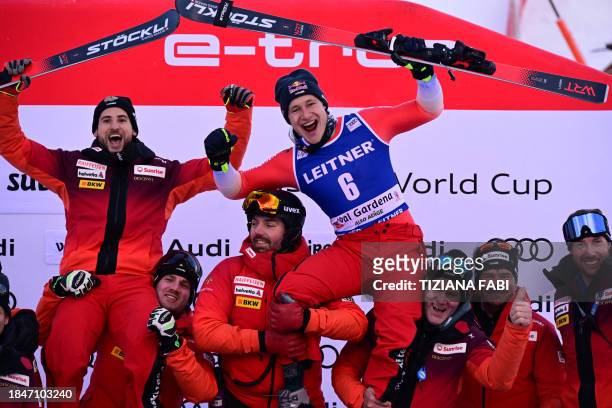 Third placed Switzerland's Marco Odermatt celebrates with teammate Marco Kohler on the podium of the men's downhill replacing Zermatt-Cervinia's...