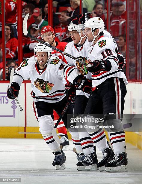 Niklas Hjalmarsson and Marian Hossa of the Chicago Blackhawks congratulate teammate Patrick Sharp following his first period goal against the...