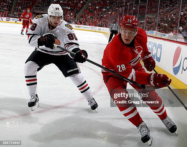 Alexander Semin of the Carolina Hurricanes chases the puck while being stick checked by Patrick Kane of the Chicago Blackhawks during their NHL game...