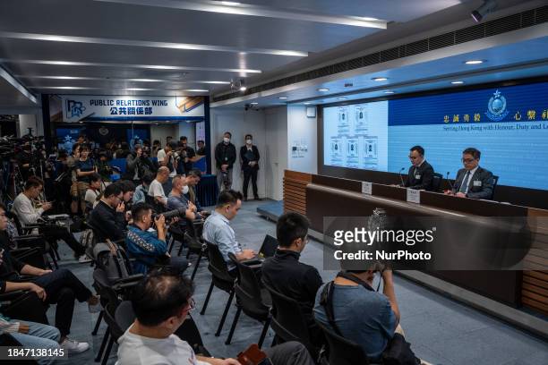 Senior Superintendent Hung Ngan and Chief Superintendent Li Kwah-wah of the National Security Department are speaking next to the wanted posters of...