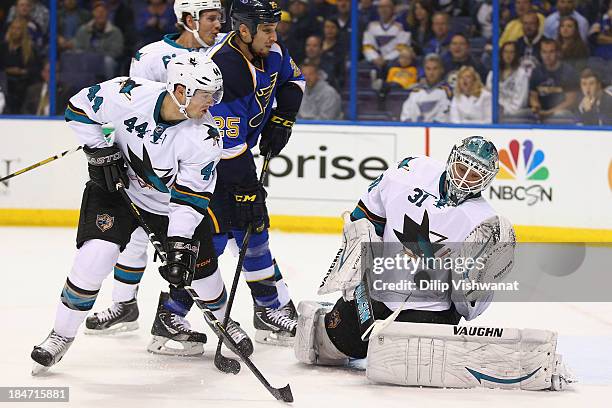 Antti Niemi of the San Jose Sharks makes a save against Chris Stewart of the St. Louis Blues as Marc-Edouard Vlasic of the Sharks defends at the...