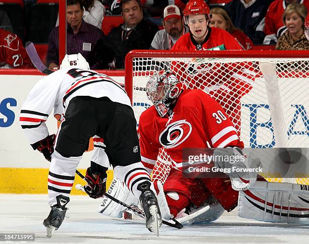 Ryan Murhpy of the Carolina Hurricanes reacts to a save by Cam Ward as Andrew Shaw of the Chicago Blackhawks closes into the goal crease during their...