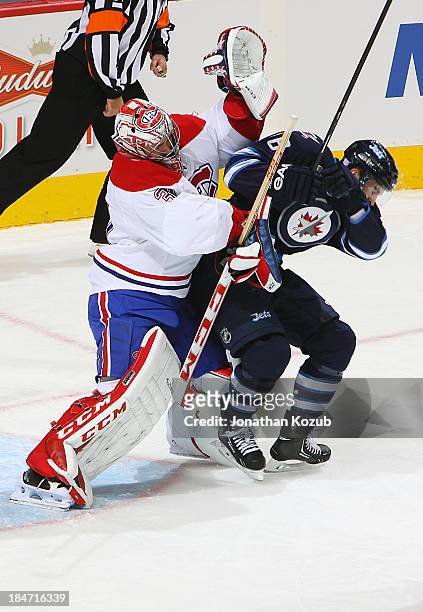 Goaltender Carey Price of the Montreal Canadiens crashes into Andrew Ladd of the Winnipeg Jets at the top of the crease during first period action at...