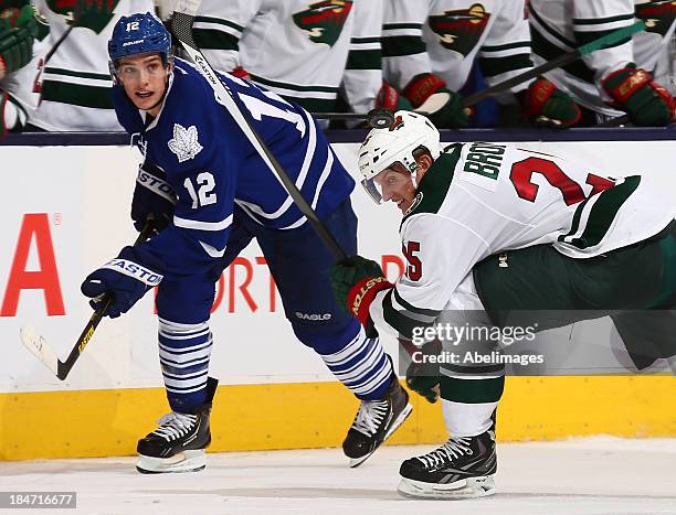 Mason Raymond of the Toronto Maple Leafs flips the puck past Jonas Brodin of the Minnesota Wild for an open net goal during NHL action at the Air...
