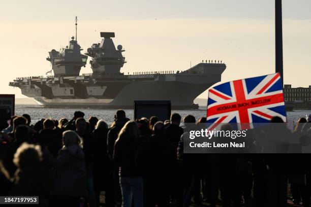 Members of the public watch as Naval personnel perform procedure alpha as they stand on deck during the arrival of the United Kingdom's biggest...