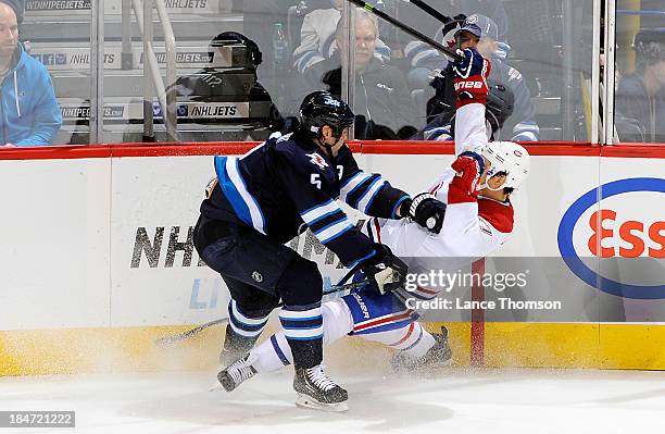 Mark Stuart of the Winnipeg Jets checks Rene Bourque of the Montreal Canadiens along the boards during second period action at the MTS Centre on...