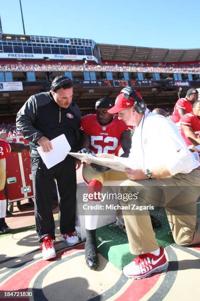 Defensive Line Coach Jim Tomsula and Linebackers Coach Jim Leavitt of the San Francisco 49ers talk with Patrick Willis during the game against the...