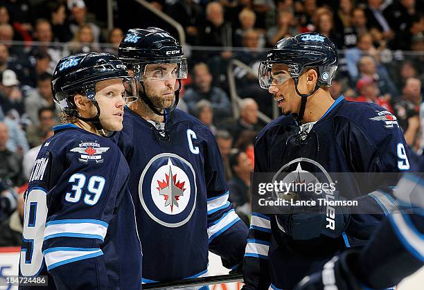 Tobias Enstrom, Andrew Ladd and Evander Kane of the Winnipeg Jets talk during a game against the Montreal Canadiens during a third period stoppage at...