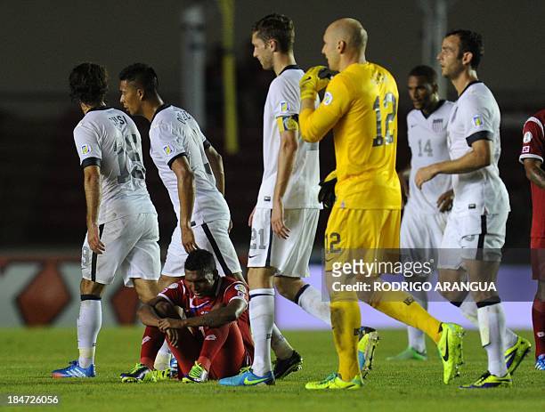 S players leave the field as a Panamanian player sits in dejection in the end of their Brazil 2014 FIFA World Cup Concacaf qualifier match against...