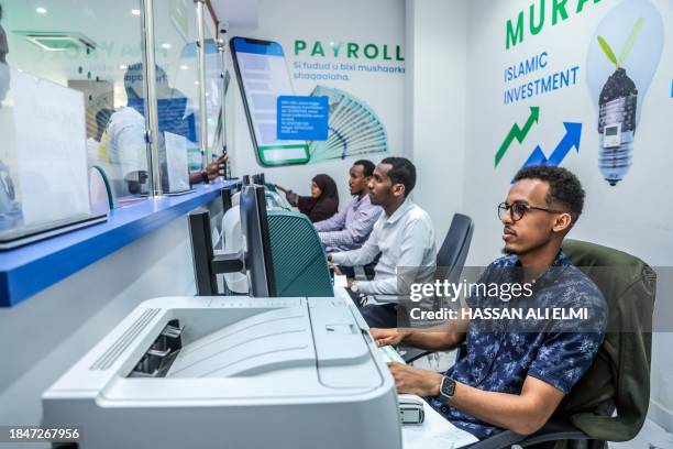 Bank teller attends some costumers at the Salaam Bank in Mogadishu on December 14, 2023. Somalia will benefit from a major $4.5 billion debt...