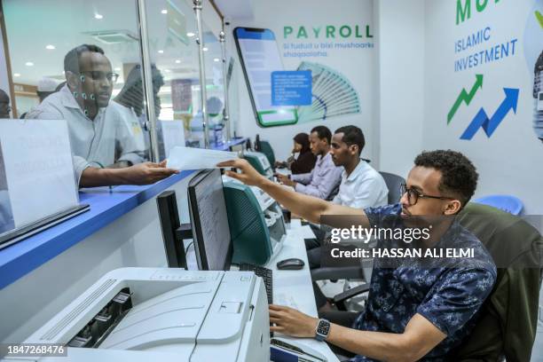 Bank teller attends a costumer at the Salaam Bank in Mogadishu on December 14, 2023. Somalia will benefit from a major $4.5 billion debt reduction...