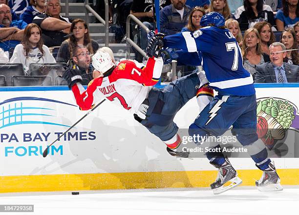 Pierre-Cedric Labrie of the Tampa Bay Lightning checks Dmitry Kulikov of the Florida Panthers at the Tampa Bay Times Forum on October 10, 2013 in...