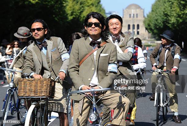 In a picture taken on October 14 people wearing tweed jackets and pants pose for a photo during the opening event of Japan Fashion Week called "Tweed...