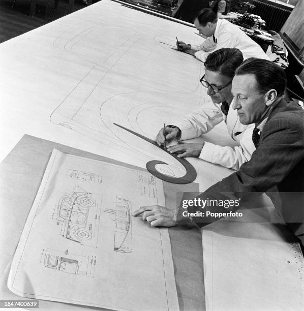 In the drawing office, Chief Body draughtsman H Daniels discusses plans for the new Wolseley Eight car with a senior draughtsman over plans and...