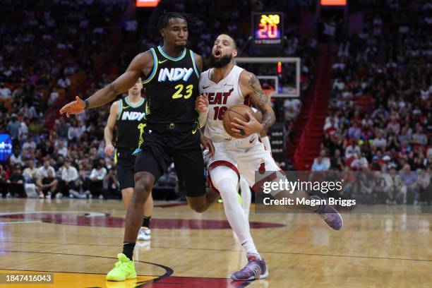 Caleb Martin of the Miami Heat drives against Aaron Nesmith of the Indiana Pacers during the first quarter at Kaseya Center on December 02, 2023 in...