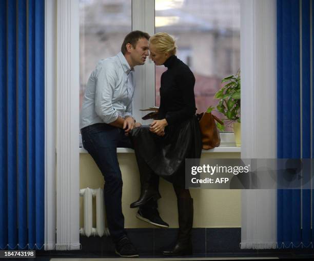 Russian protest leader Alexei Navalny speaks with his wife Yulia during a break at the hearing of his case in a court in the provincial northern city...