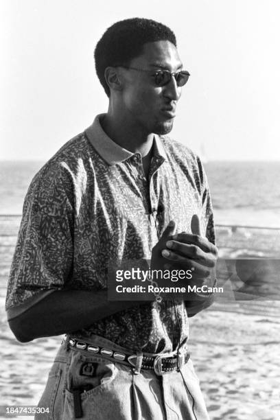 Scottie Pippen of the Chicago Bulls is interviewed wearing sunglasses, a collared print shirt, jeans, and embellished belt, and a bracelet on the set...
