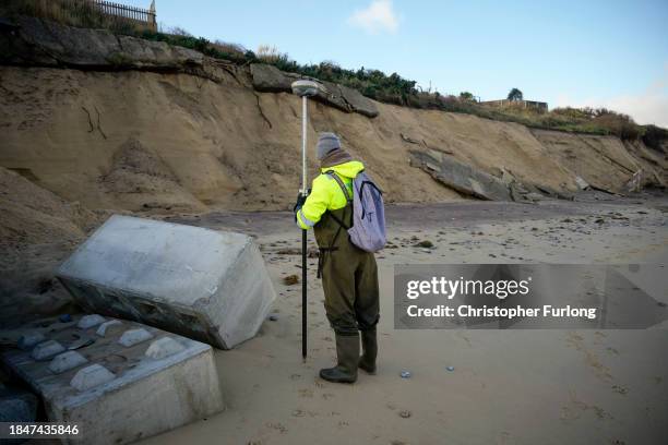 Land surveyor measures beach and sand erosion using GPS on Hemsby beach on December 11, 2023 in Hemsby, England. The collapse of a private access...