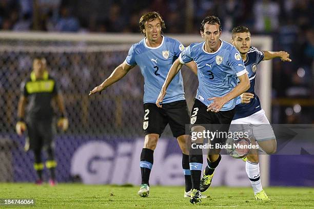 Diego Lugano and Diego Godin of Uruguay vies for the ball with Sebastian Dominguez of Argentina during a match between Uruguay and Argentina as part...