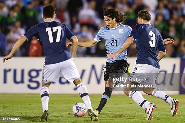 Edinson Cavani of Uruguay vies for the ball with Federico Fernandez and Hugo Campagnaro of Argentina during a match between Uruguay and Argentina as...