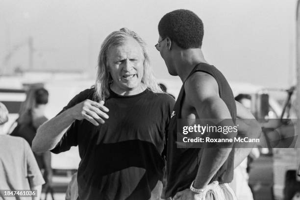 Joe Pytka discusses a shot with Scottie Pippen of the Chicago Bulls who is wearing sunglasses and a tank top on the set of a Nike commercial at a...