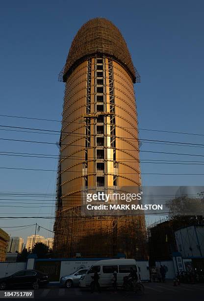 The new headquarters of the People's Daily newspaper is clad in gold tinted glass during its construction in Beijing on the 16 October, 2013....