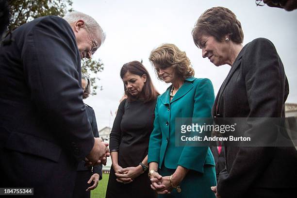 Reverend Jim Wallis prays with Sen. Kelly Ayotte , Sen. Lisa Murkowski and Sen. Susan Collins in front of the Capitol Building on the morning of...