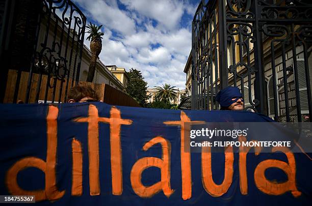 Activists hold a banner reading "dictatorship" after occupying the European System of Central Banks and eurosystem offices of the Bank of Italy to...