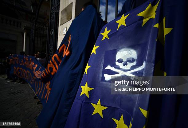 Activists hold a European Union flag with a jolly rodger painted on after occupying the European System of Central Banks and eurosystem offices of...