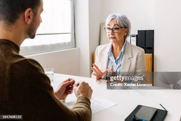 senior woman talking with hr male recruiter during job interview. businessman asking senior female candidate questions about her professional career. - job vacancy stock pictures, royalty-free photos & images