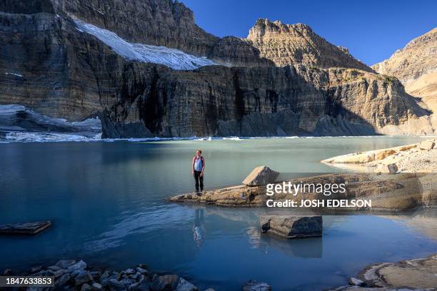 Hiker Ryan Bergman of Florida, views the upper Grinnell Lake and the remains of the Salamander Glacier and the Grinnell Glacier in Glacier National...