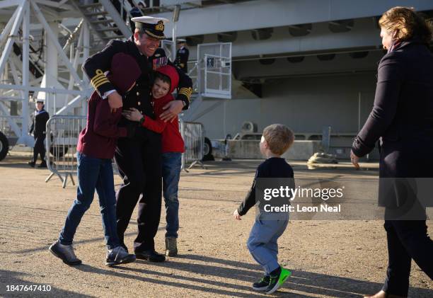 Captain Richard Hewitt, commanding officer of HMS Prince of Wales, hugs his sons Oliver and William as he prepares to reunite with the rest of his...