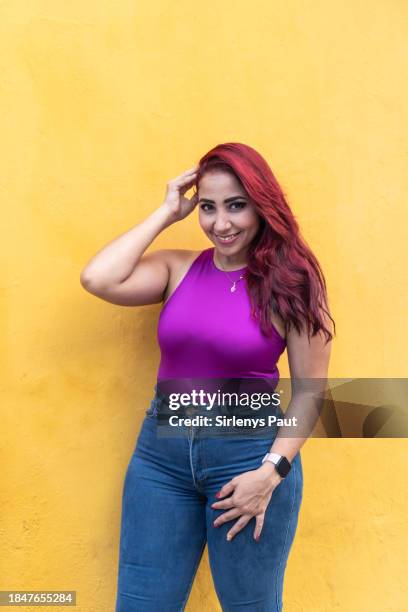 donna alla moda con i capelli rossi contro il muro giallo - maglietta senza maniche foto e immagini stock