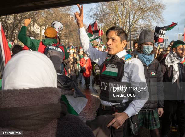 London, UK, Dec 9 2023, A Muslim man wearing a vest stating "Stop the War" raises his hand at a pro-Palestinian demonstration calling for an end to...