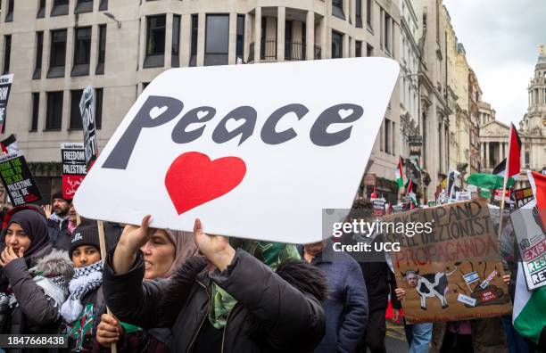 London, UK, Dec 9 2023, A woman carries a poster saying "Peace" at a pro-Palestinian demonstration calling for an end to Israeli attacks on Gaza.