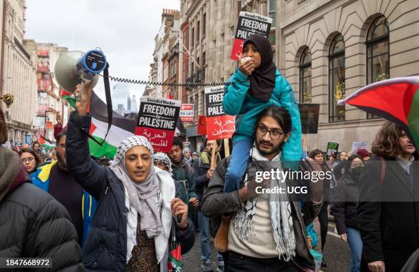 London, UK, Dec 9 2023, A father carries his daughter who leads chants with her mother at a pro-Palestinian demonstration calling for an end to...