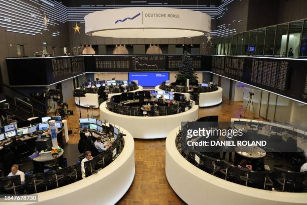 Traders work in front of a chart of Germany's share index DAX that is diplayed at the stock exchange in Frankfurt am Main, western Germany. German...