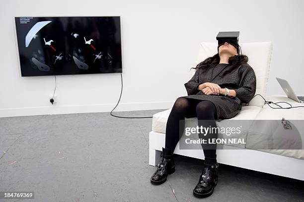 Woman watches a virtual presentation of "Frame" by US artist Ian Cheng and the Formalist Sidewalk Poetry Club at the Frieze London art fair in...